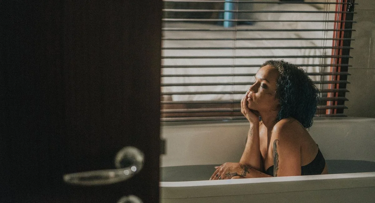 Woman enjoying a calming moment in a bathtub, highlighting relaxation and serenity indoors.